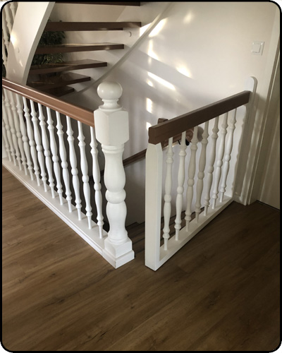 Weiß lackierte Treppe mit Holzhandlauf